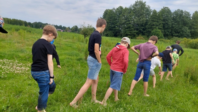 Bērni iet pa pļavu