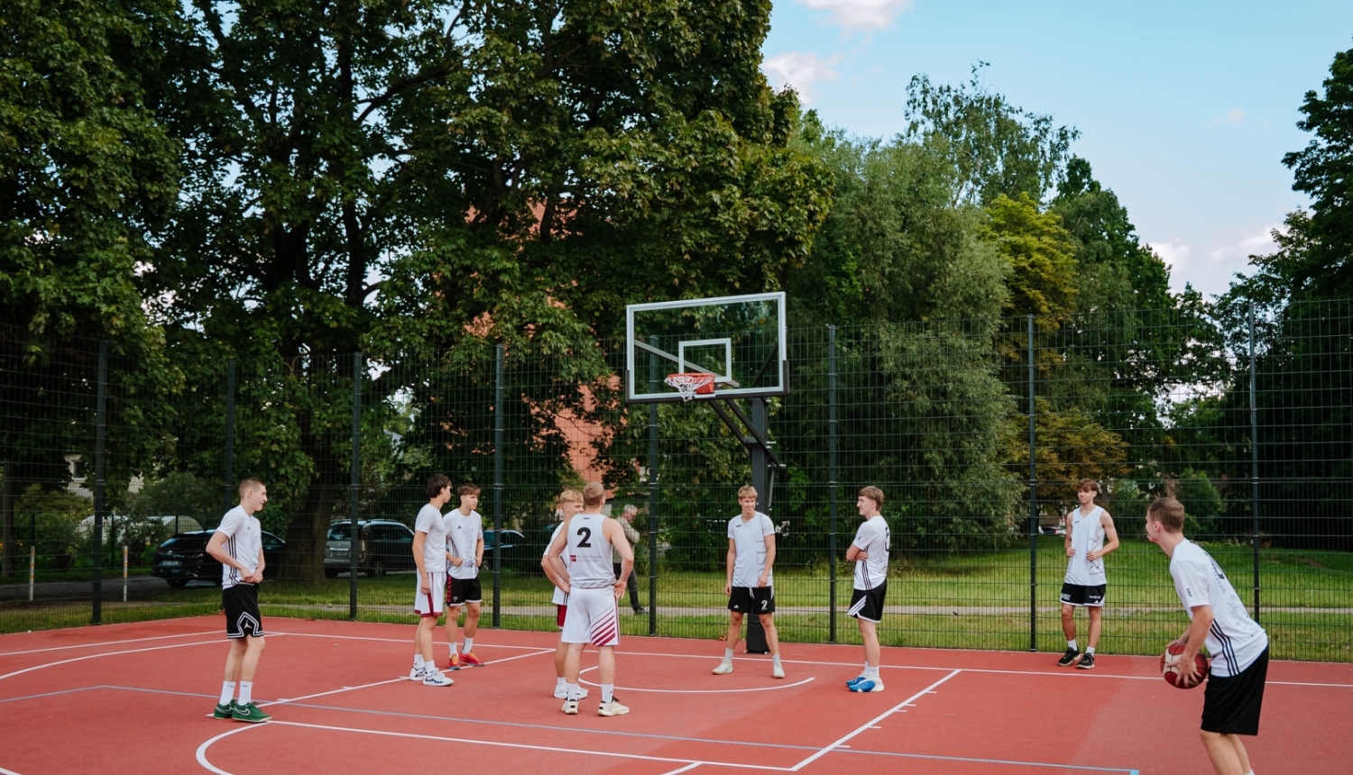 Sporta laukumā spēlē basketbolu