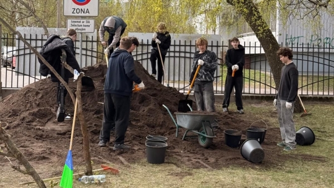Cilvēki izlīdzina melnzemes kaudzi