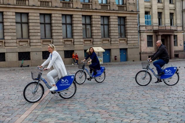 Cilvēki brauc ar velosipēdu