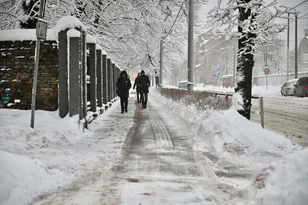 Cilvēki iet pa ielu ziemā