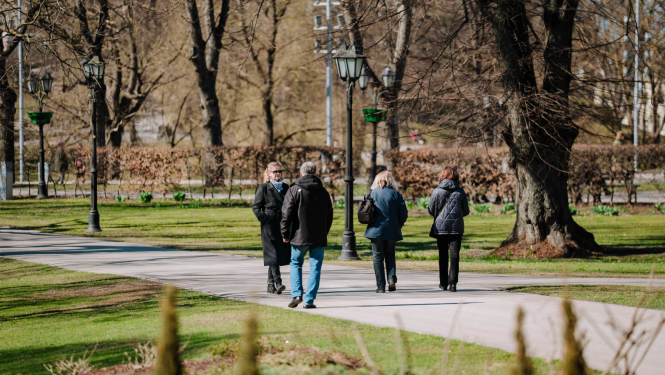 Cilvēki pastaigājas parkā