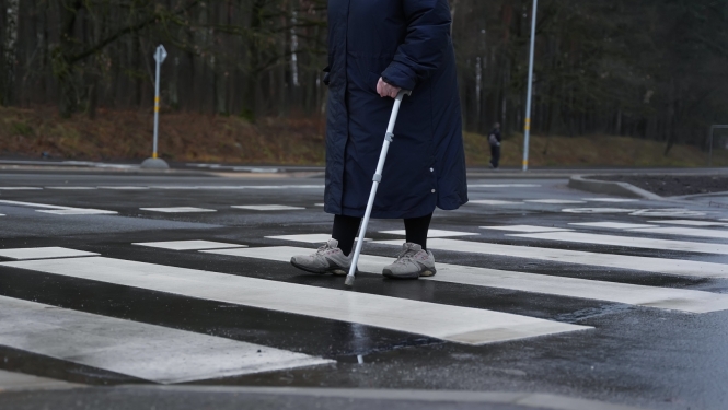 Cilvēks iet pa gājēju pāreju