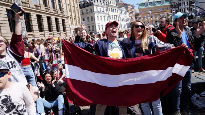 Hokeja fani ar Latvijas karogu rokā