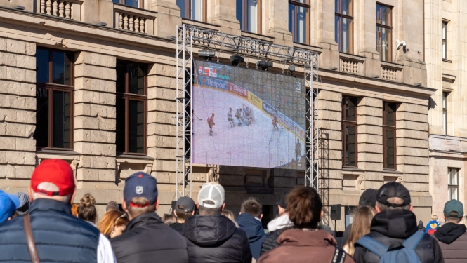 Cilvēki skatās hokeju Doma laukumā