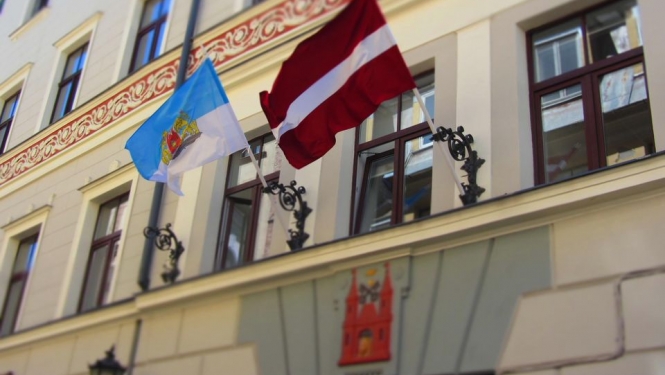Īpašuma departamenta ēka ar Rīgas un Latvijas karogiem