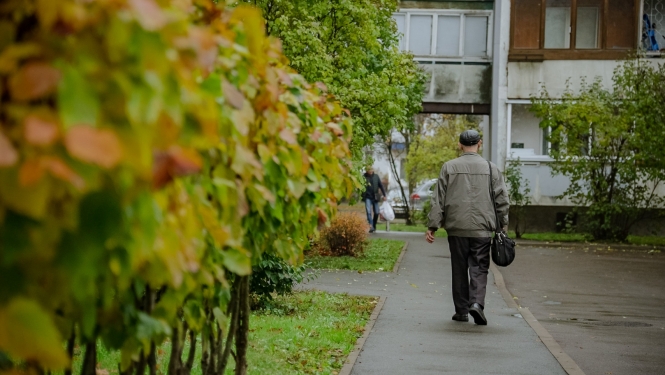 Cilvēks iet pa ielu uz māju