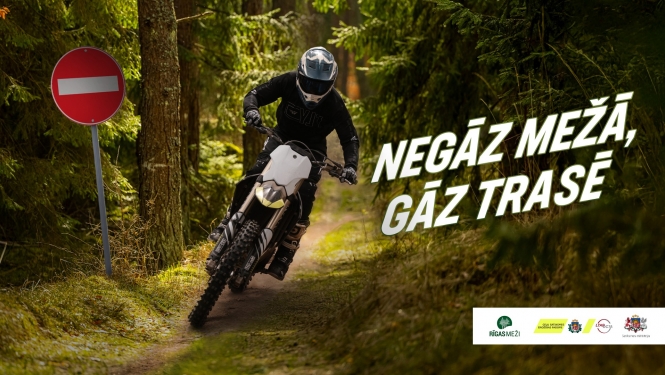 Cilvēks uz motocikla mežā