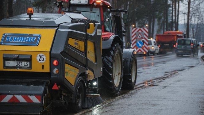 Traktors tīra ielu
