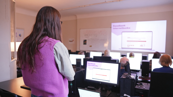 Cilvēki sēž pie datoriem un mācās