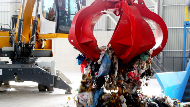 Ceļamkrāns izkrauj atkritumus