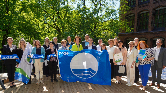 Cilvēki rokās tur zilo karogu