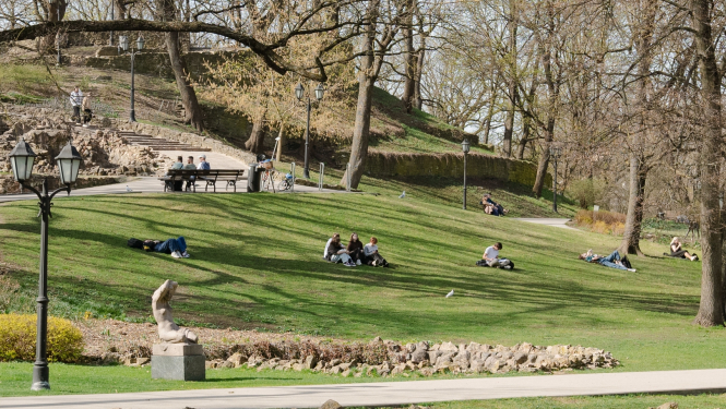 Cilvēki sēž zālītē Bastejalnā