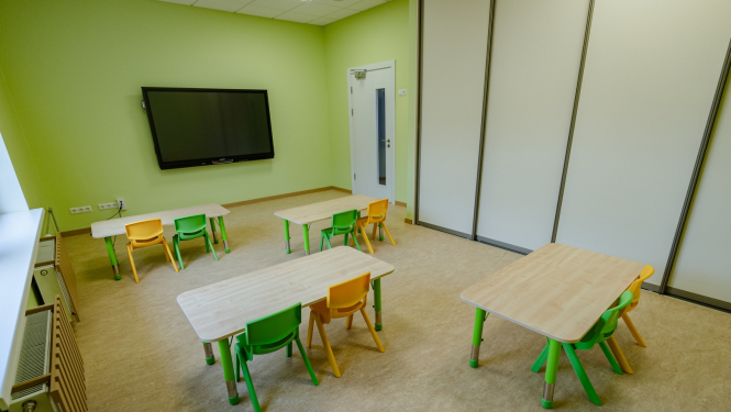 Bērnudārza grupiņa ar galdiem un krēsliem