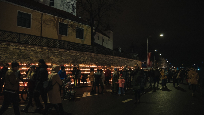 Cilvēki liek svecītes 11.novembra krastmalā