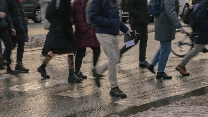 Cilvēki iet pāri gājēju pārejai