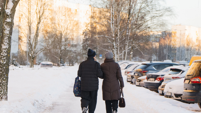 Cilvēki iet pas niegotu ielu