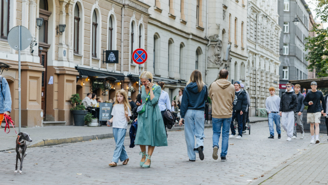 Cilvēki iet pa ielu