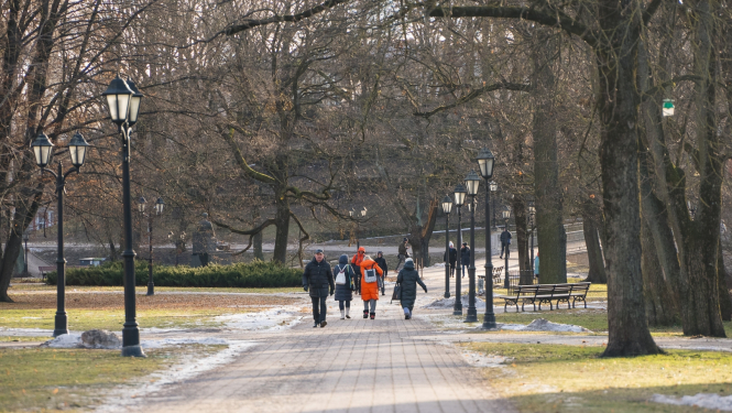 Cilvēki staigā pa parku