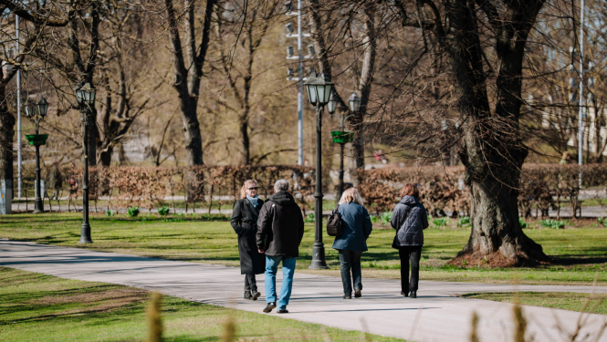 Cilvēki pastaigājas parkā