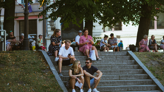 Cilvēki sēž uz kāpnēm