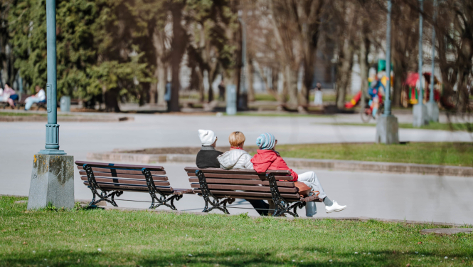 Cilvēki sēž uz soliņa