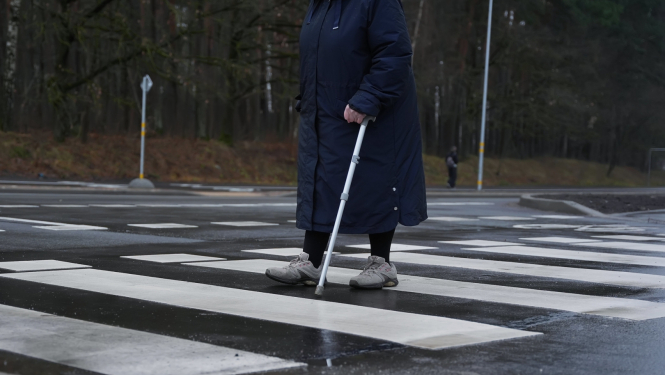 Cilvēks iet pa gājēju pāreju