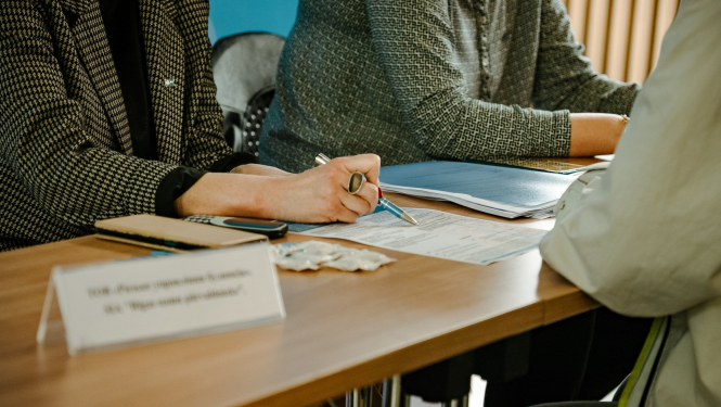 Cilvēki sēž pie galda