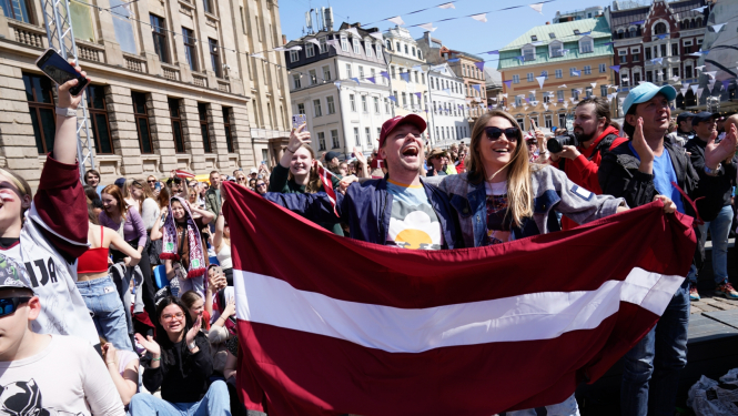 Hokeja fani ar Latvijas karogu rokā