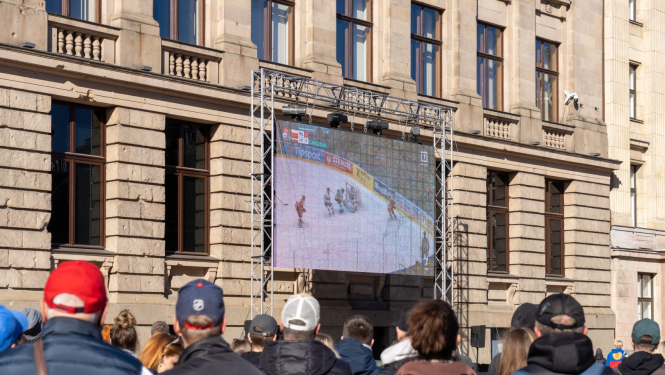 Cilvēki skatās hokeju Doma laukumā