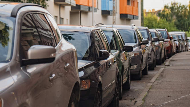 Ielas malā stāv automašīnas