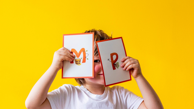 Bērns rāda burtu kartītes