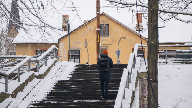 Cilvēks ziemā kāpj pa kāpnēm