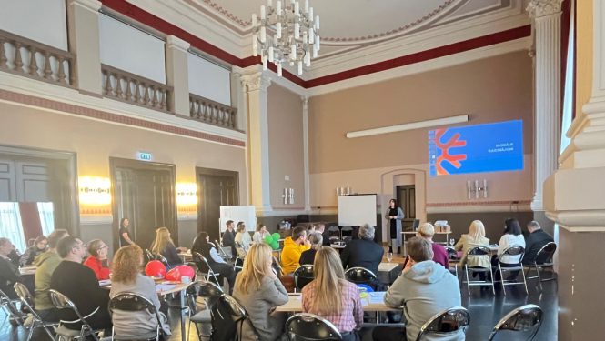 Cilvēki sēž pie galdiem