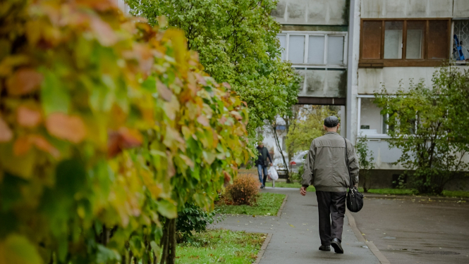 Cilvēks iet pa ielu uz māju