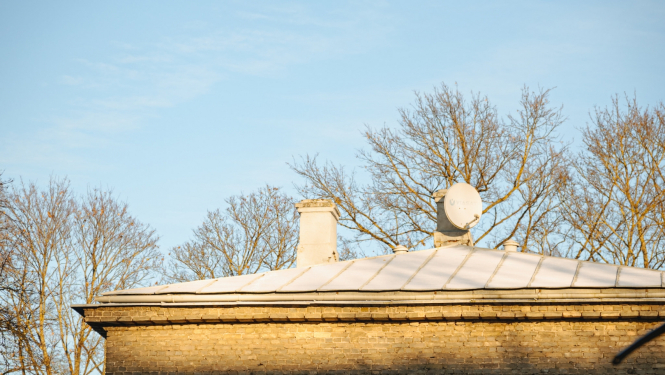 Mājas jumts ar skursteni un satelīta antenu