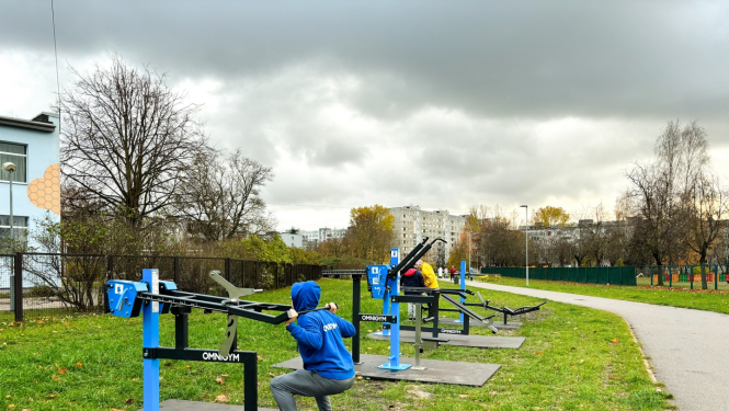 Cilvēki trennējas uz āra trenažieriem