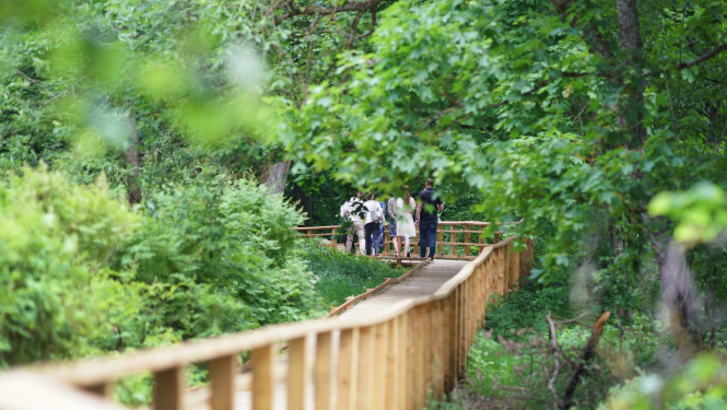 Cilvēki iet pa pastaigu taku