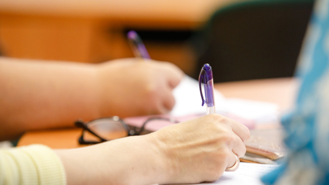 Uz papīra raksta ar pildspalvu