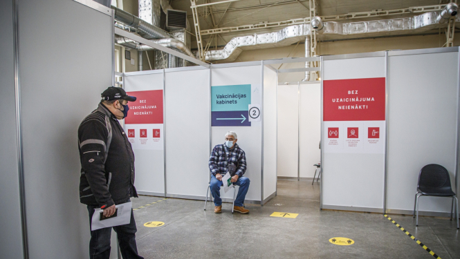 Cilvēki gaidā rindā uz vakcīnu 