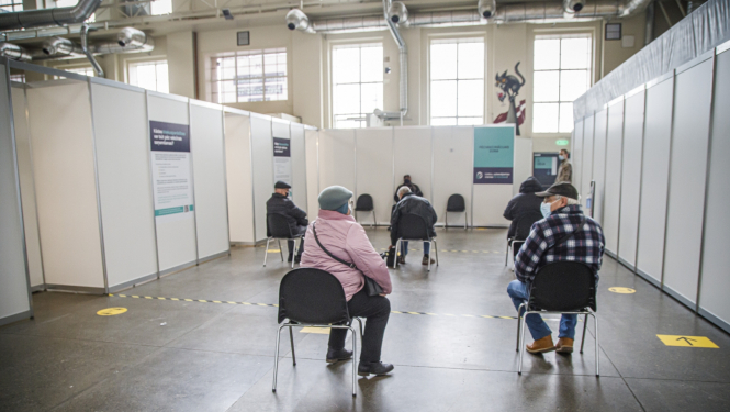 Cilvēki gaidā rindā uz vakcīnu 