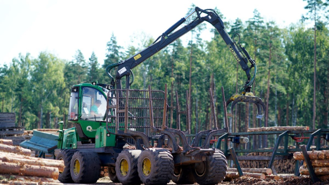 Traktors krāmē kokus