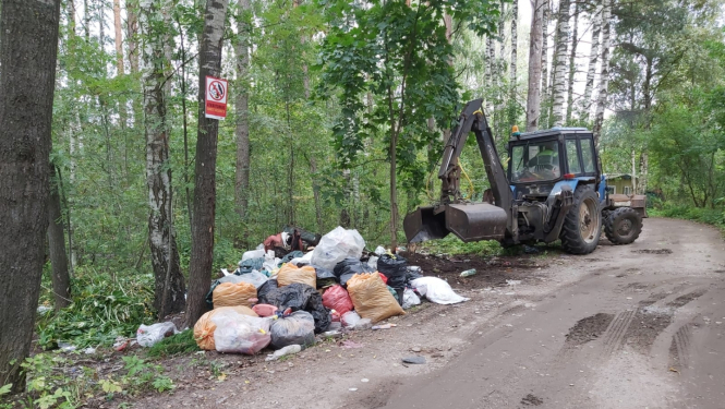 Traktors savāc atkritumu maisus