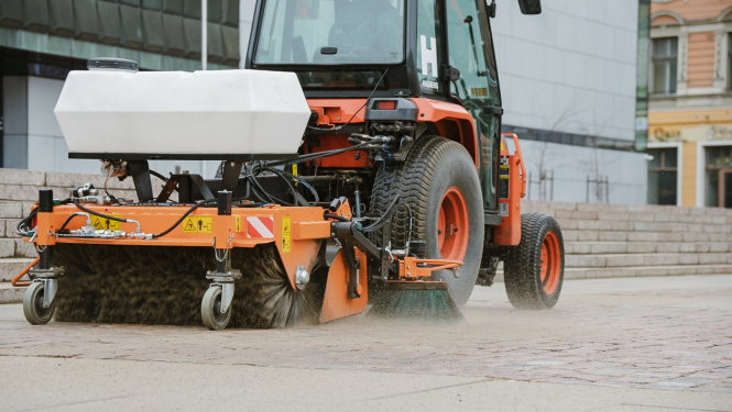 Traktors savāc smiltis