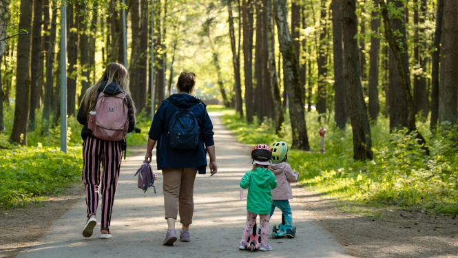 Sievietes ar bērniem pastaigājas parkā
