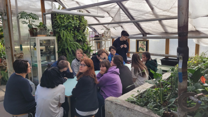 Skolēni sež pie liela galda un mācās