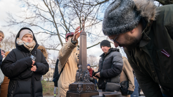 Cilvēki apskata tkatilo Brīvības pieminekli