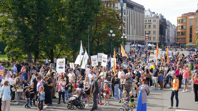 Cilvēki iet gājienā gar Brīvības pieminekli