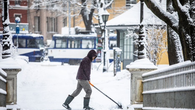 Cilvēks tīra sniegu