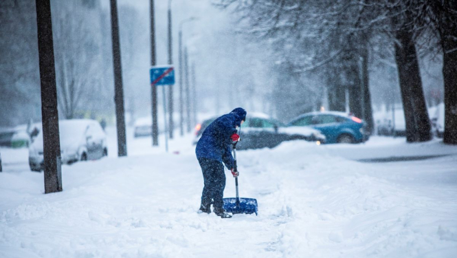 Cilvēks tīra sniegu